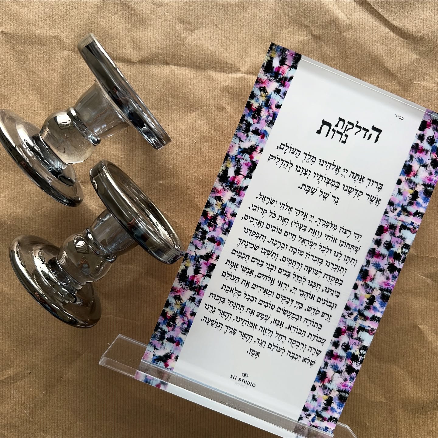 Close-up of Shabbat Spark candle lighting blessing set, Hebrew text with colorful hand-painted background