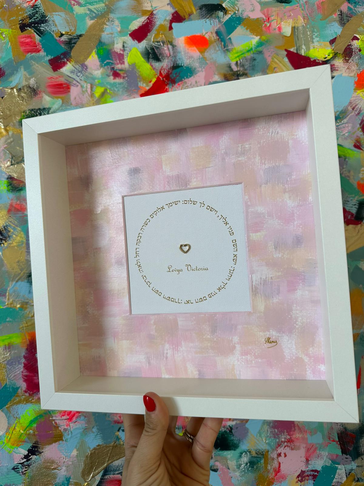 Close-up of Birkat HaYeladim pink children's blessing with heart detail, Hebrew calligraphy in white frame, Jewish nursery art