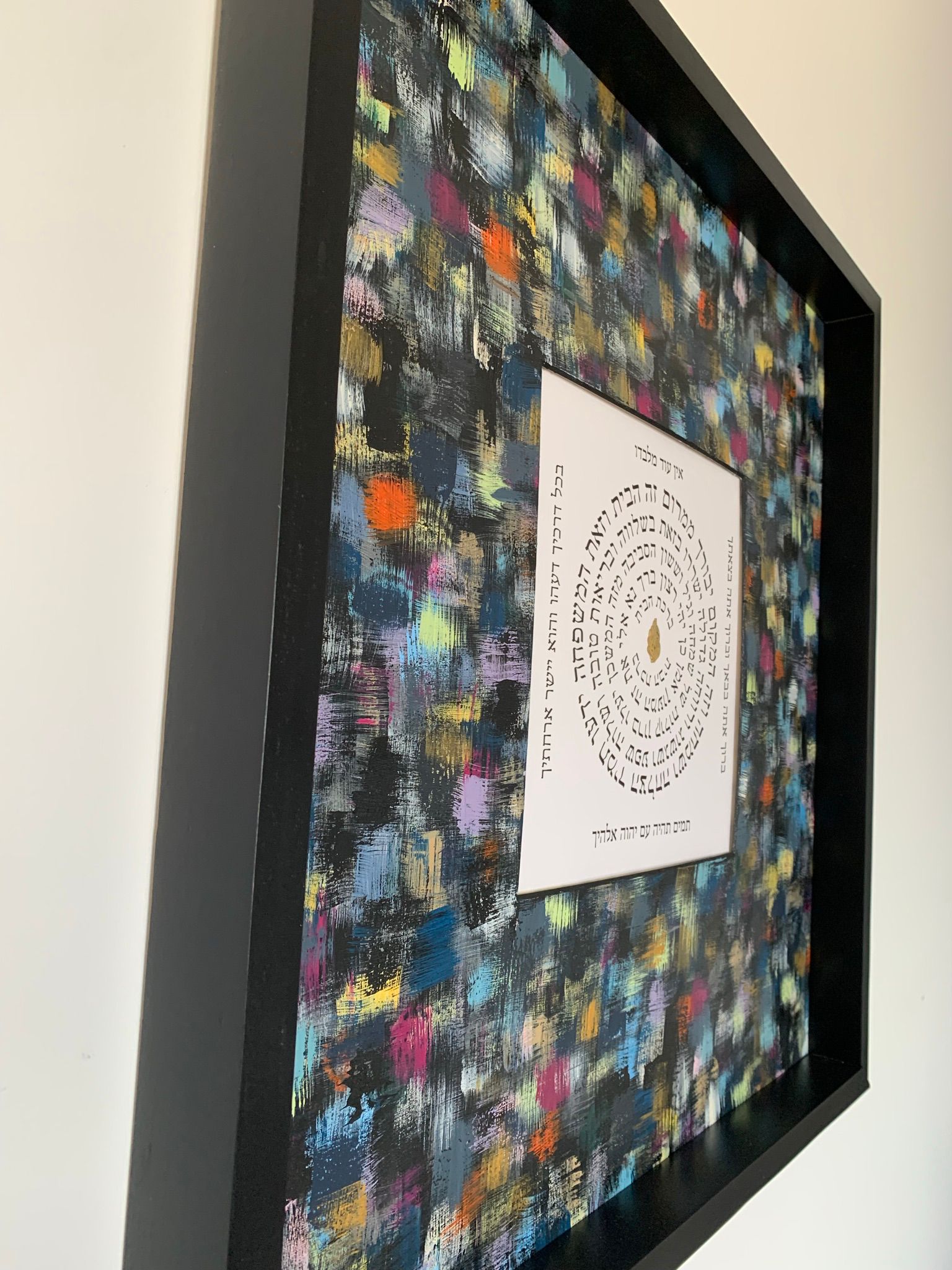 Birkat HaBayit personalized multicolor in black frame, side angle view of Hebrew home blessing Judaica wall art