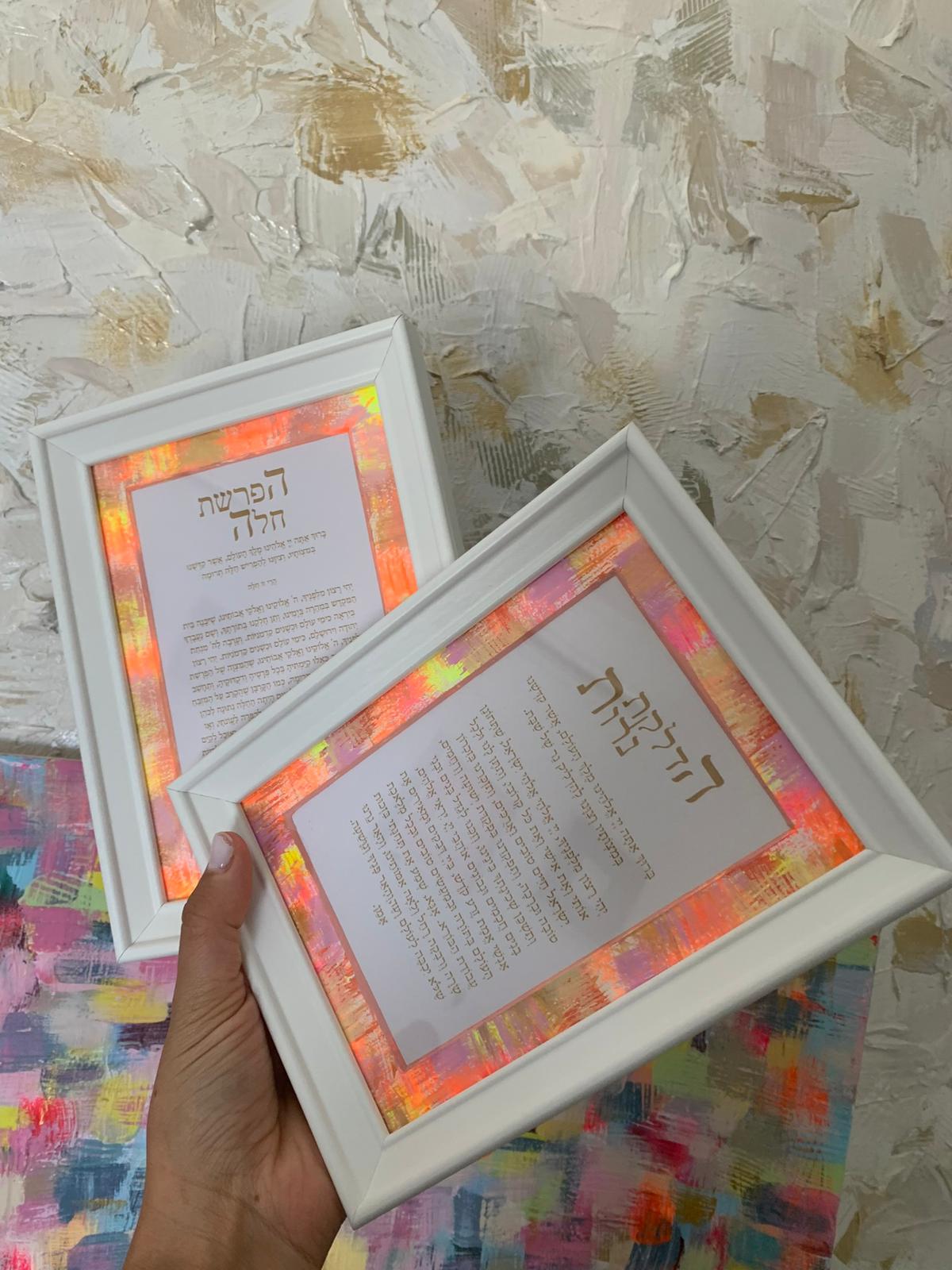 Close-up of Set for Shabbat neon orange pair, framed Shabbat blessings with vibrant orange and pink hand-painted borders